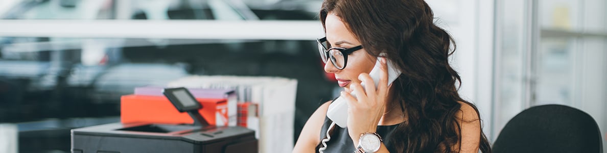 A woman on a phone in an office.