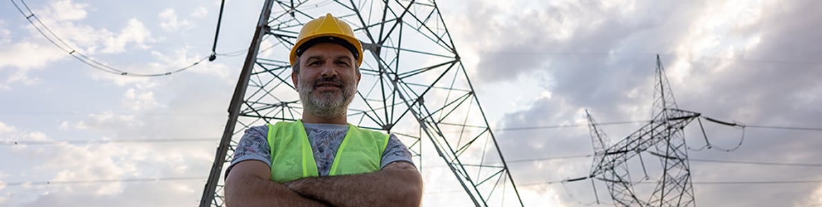 A man smiling in front of power lines.