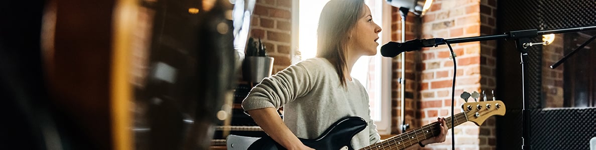 A woman playing a bass guitar.