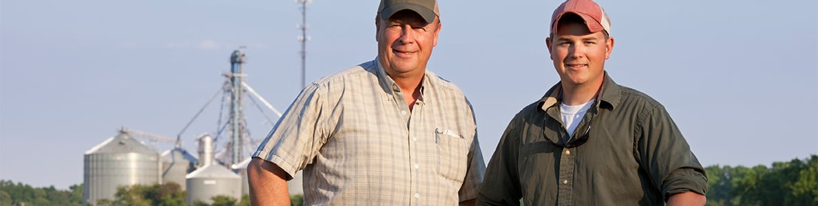 Two farms smiling in front of slios.