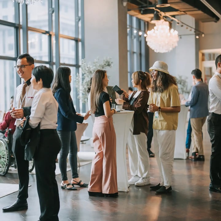 Une salle bondée remplie de gens debout ensemble, engagés dans des conversations et des interactions.