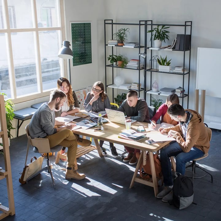 Group of people at a startup sitting around a table networking.