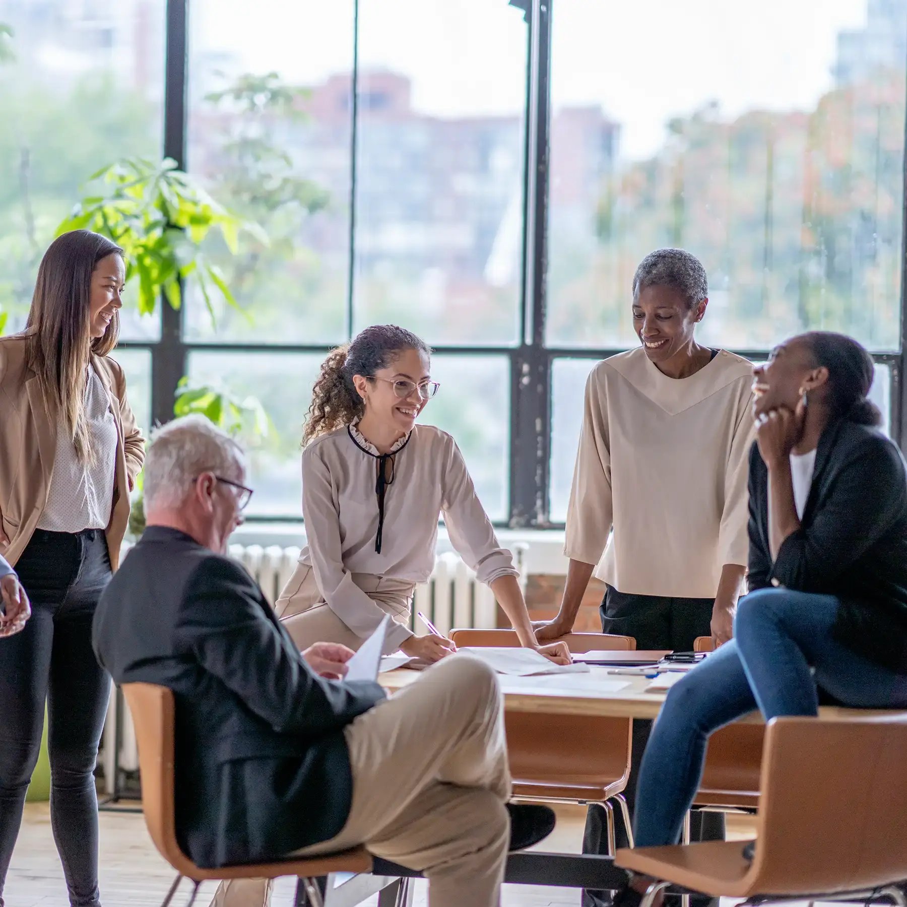 A diverse group of professionals engaged in a collaborative discussion during an office meeting.