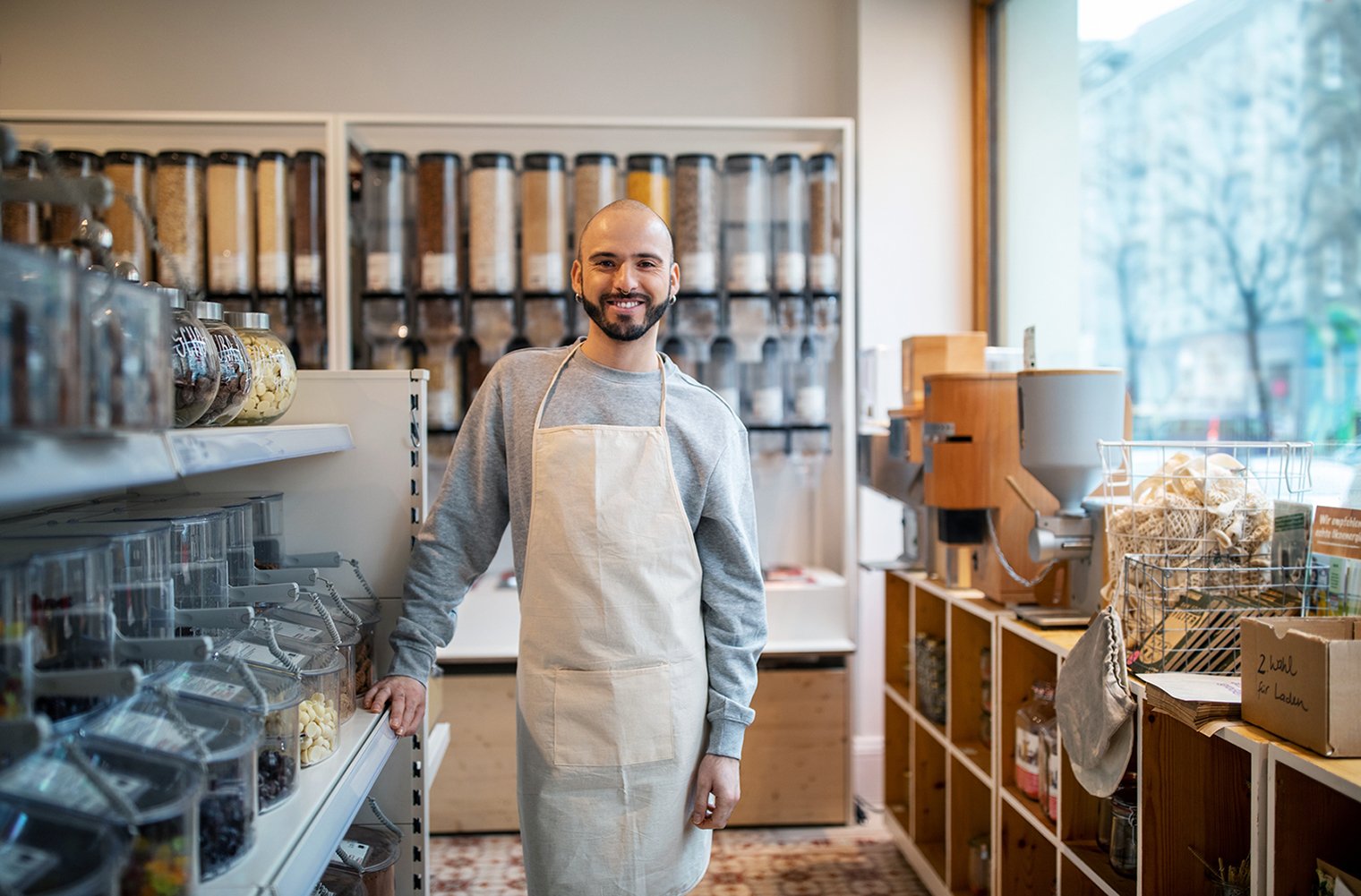  A man wearing an apron smiling in a refillery.