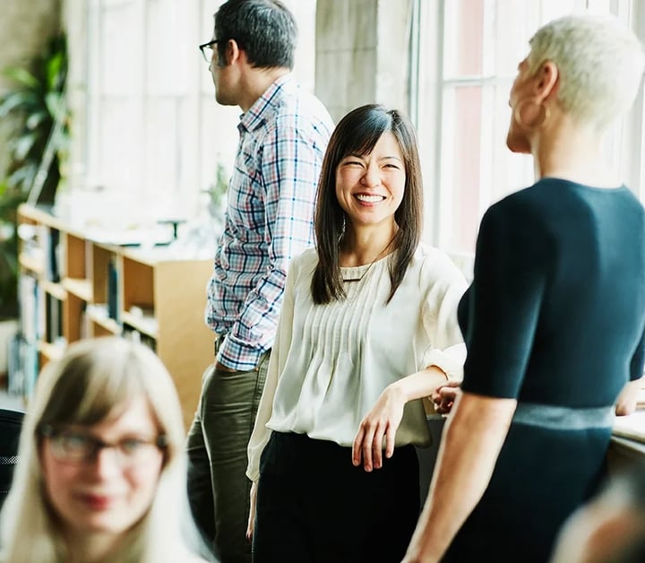  A diverse group of professionals gathered in an office, engaged in discussion and collaboration.