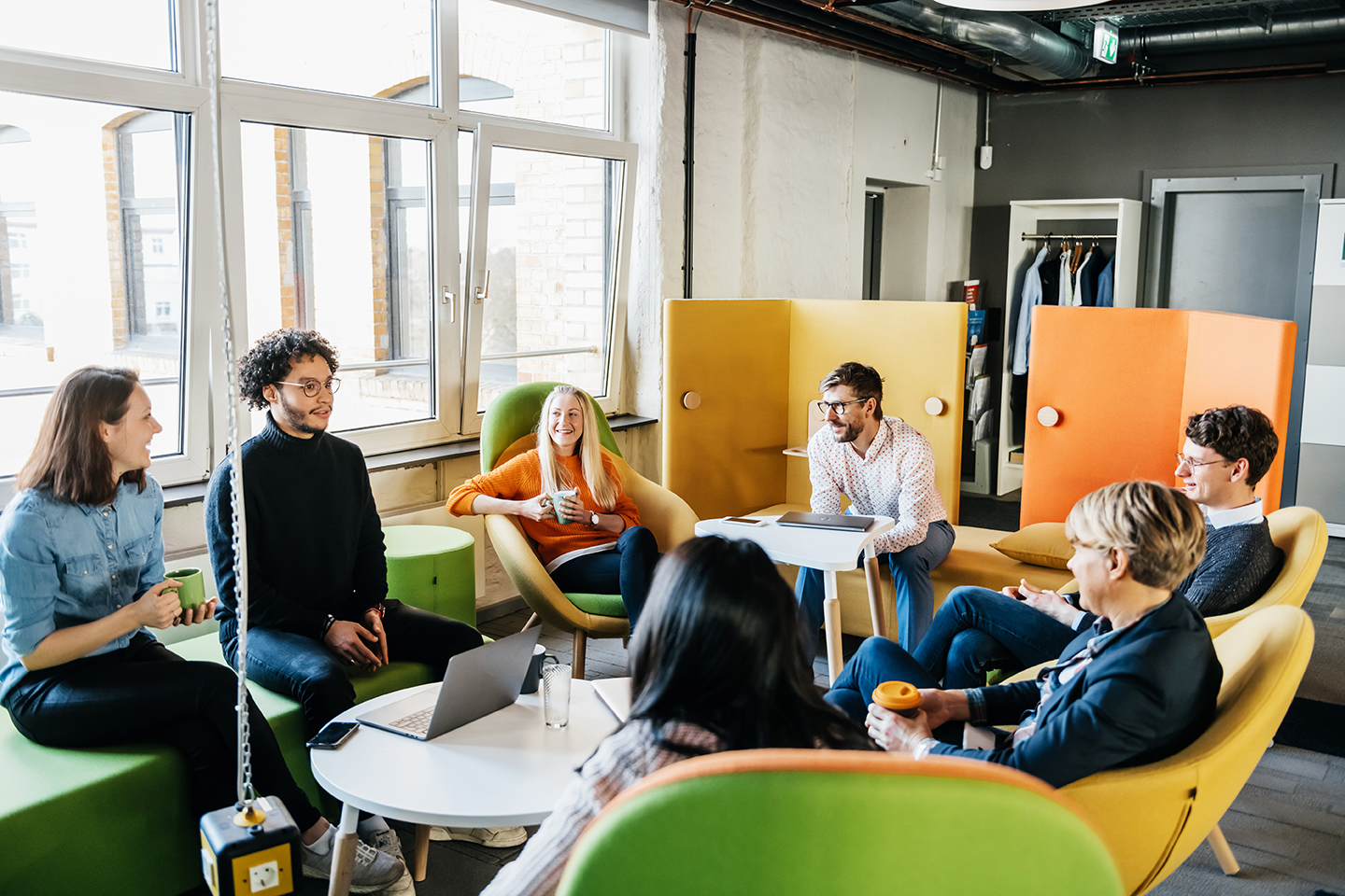 Male and female professionals in sitting in an office environment.