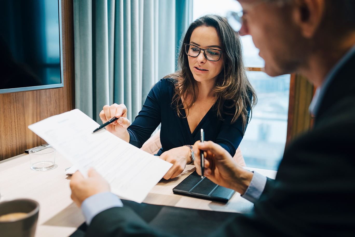 Un homme et une femme discutent de plans d’affaires dans un bureau