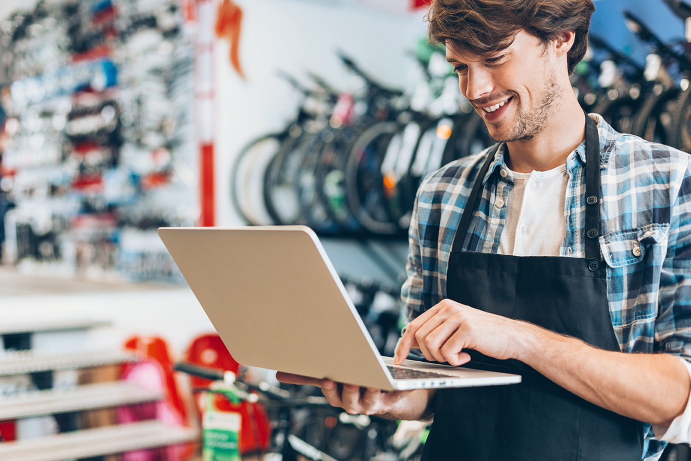 Man wearing apron on laptop.