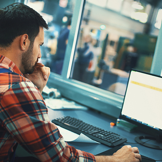 A bearded man checking his loan application on a computer