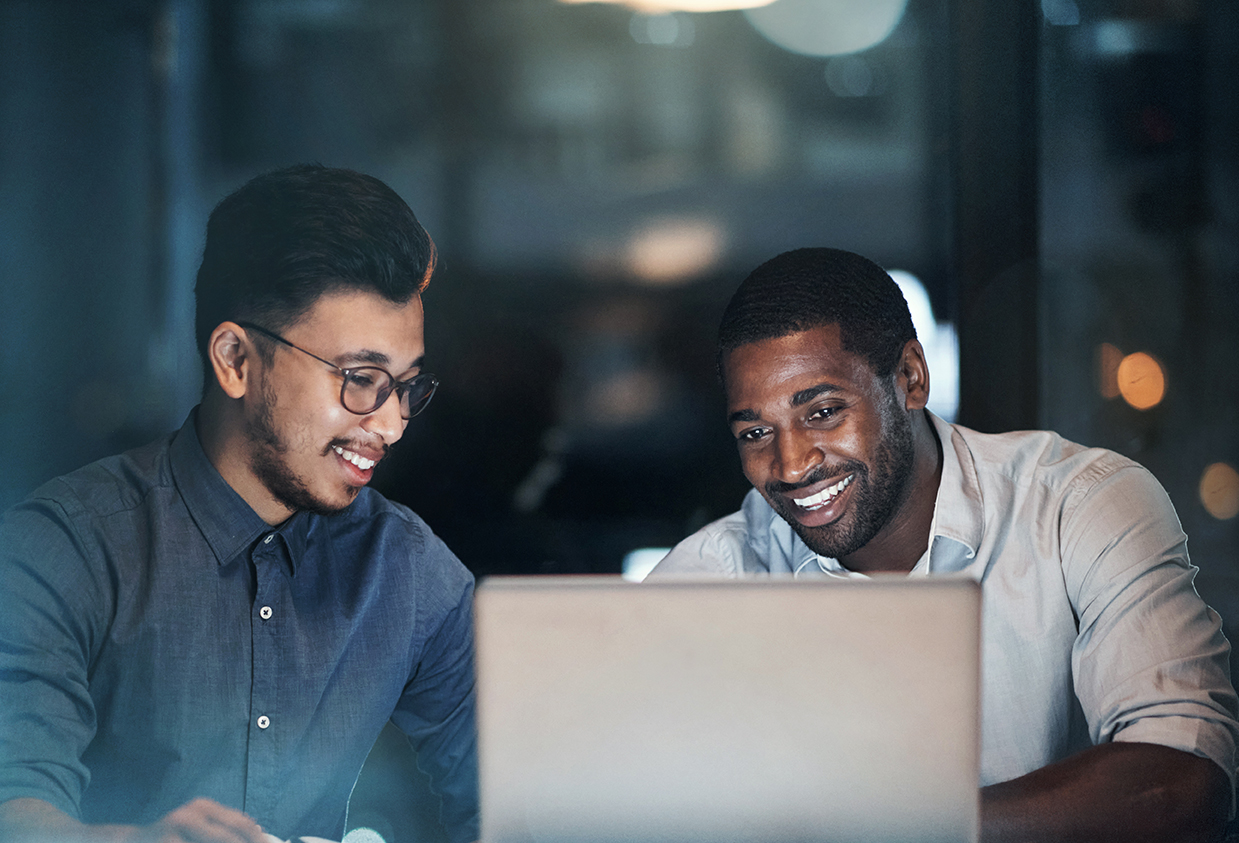 Two Cubeler Members smiling behind a laptop