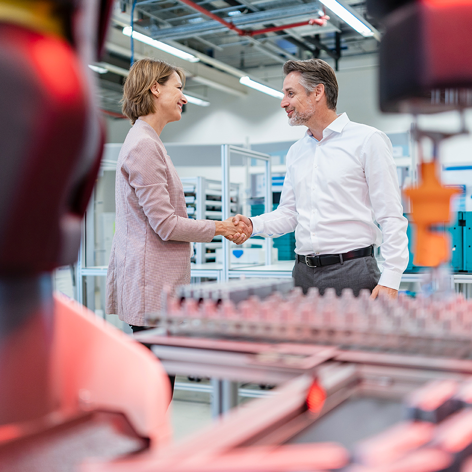 A woman shakes hands with a man in a laboratory
