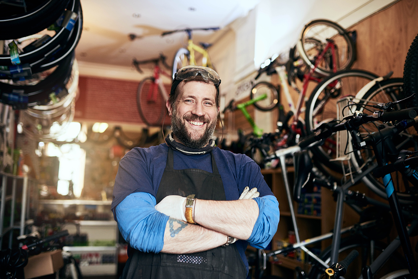 A bearded man smiles in a bike shop.
